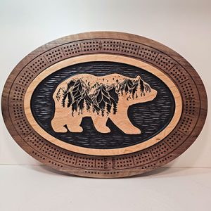 Custom wooden cribbage board with engraved bear containing wilderness scene on black background