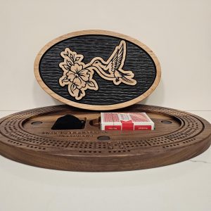 Handcrafted oval cribbage board featuring decorative hummingbird and blossom engraving on black inlay