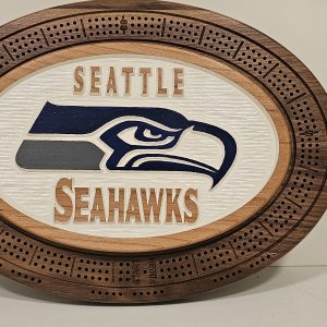 Oval wooden cribbage board with Seattle Seahawks logo in navy blue and gray on white textured center